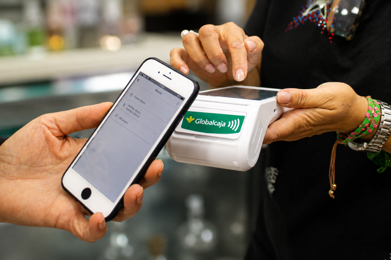 Persona pagando con el móvil mediante Bizum en un datáfono contactless