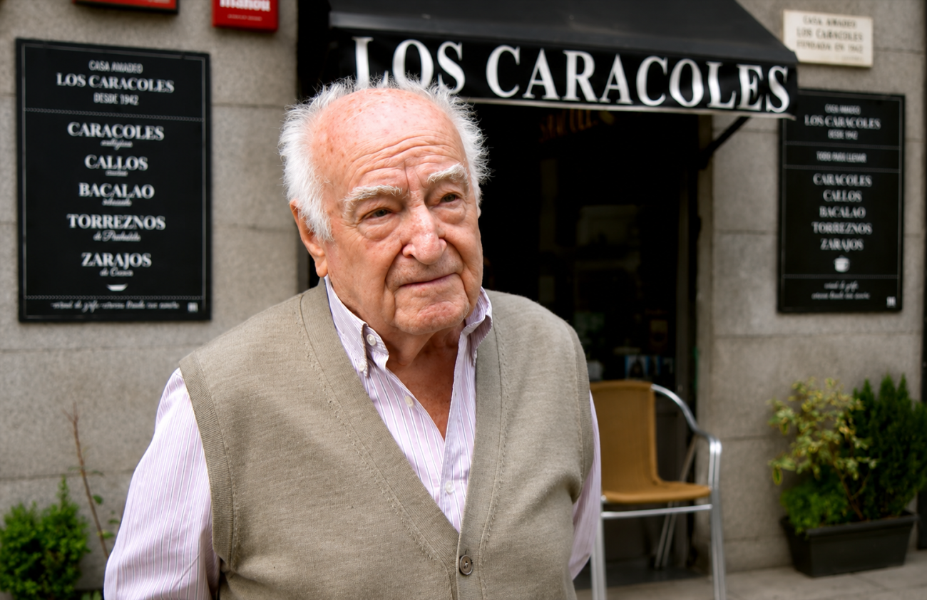 Amadeo Lázaro, tabernero de 97 años, posa frente a su establecimiento Los Caracoles, donde sigue trabajando acompañado por hijos y nietos.