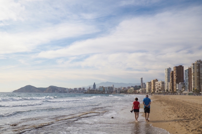 Pareja paseando por la Playa de Poniente, una de las zonas que mejor representa la transformación turística de Benidorm. Pareja paseando por la Playa de Poniente, una de las zonas que mejor representa la transformación turística de Benidorm.