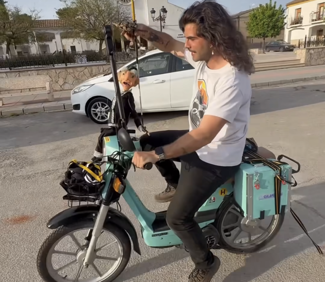 Mario Ezno en su Vespino con uno de sus títeres