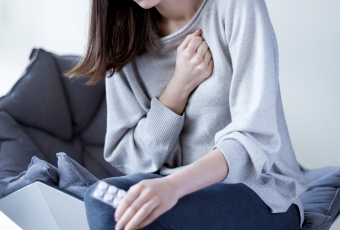 Mujer con dolor en el pecho y malestar, posibles síntomas de infarto en mujeres