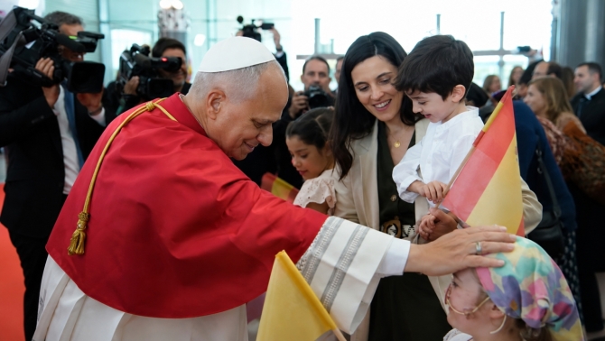 El Papa León XIV saluda a varios niños durante su llegada al aeropuerto de Madrid.