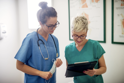 Dos profesionales sanitarias consultan una tablet en un centro médico, representando una de las FP con más salidas laborales en 2026.
