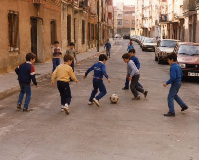 Niños jugando al fútbol en una calle de barrio durante los años 80