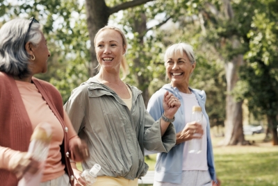Tres mujeres caminando y haciendo ejercicio al aire libre en una imagen relacionada con envejecimiento activo y salud muscular