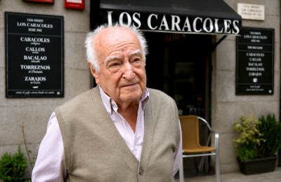 Amadeo Lázaro, tabernero de 97 años, posa frente a su establecimiento Los Caracoles, donde sigue trabajando acompañado por hijos y nietos.
